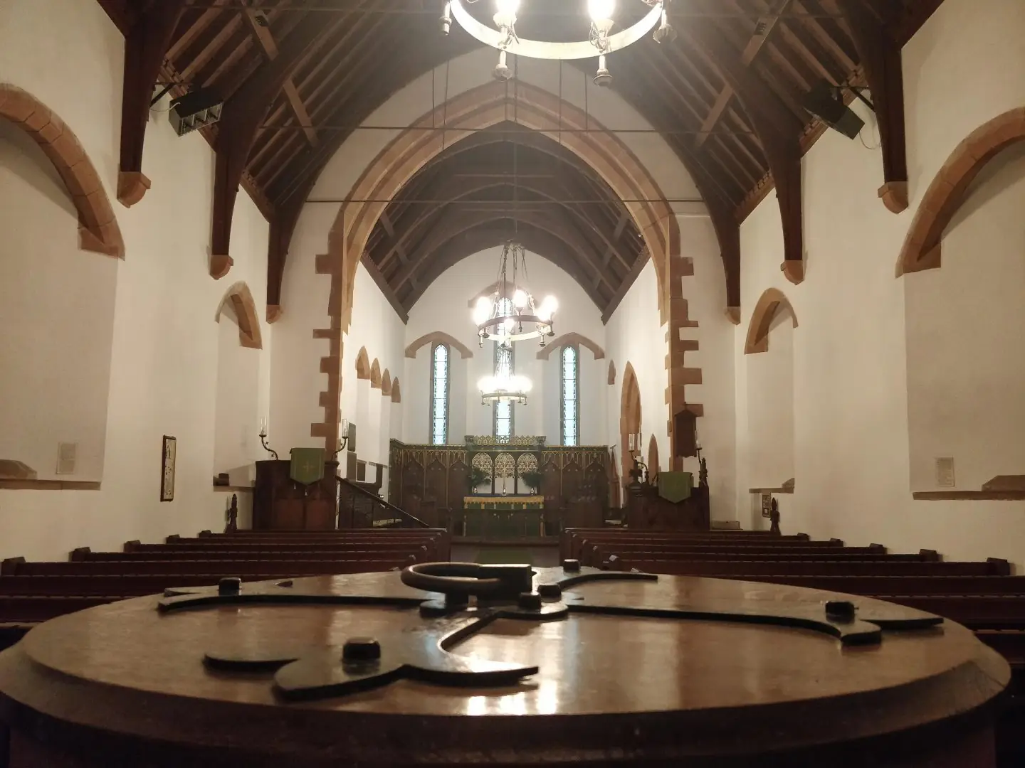 A church interior with a circular altar area and chairs
